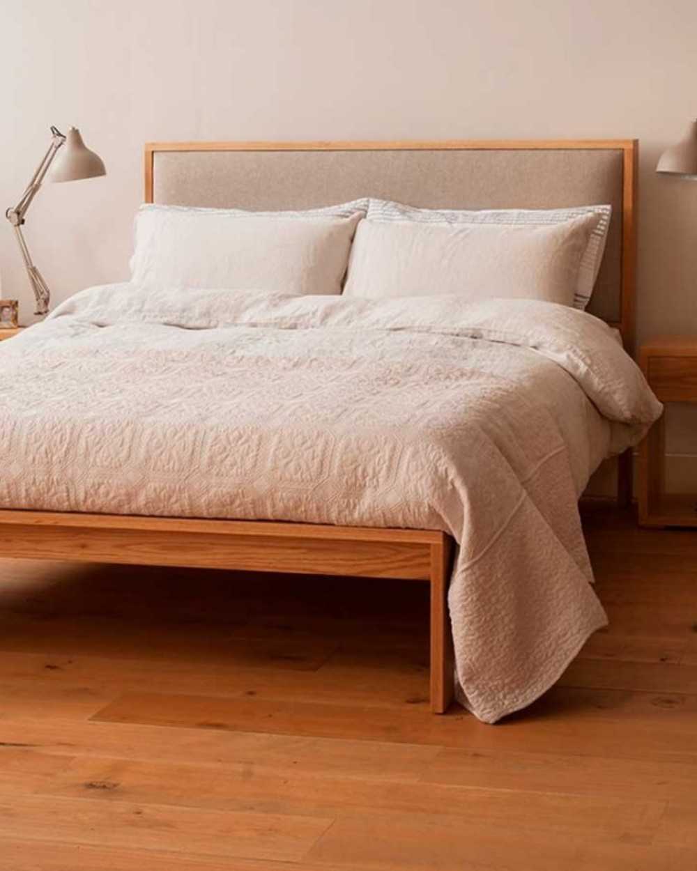 Cama de madera con cabecero tapizado